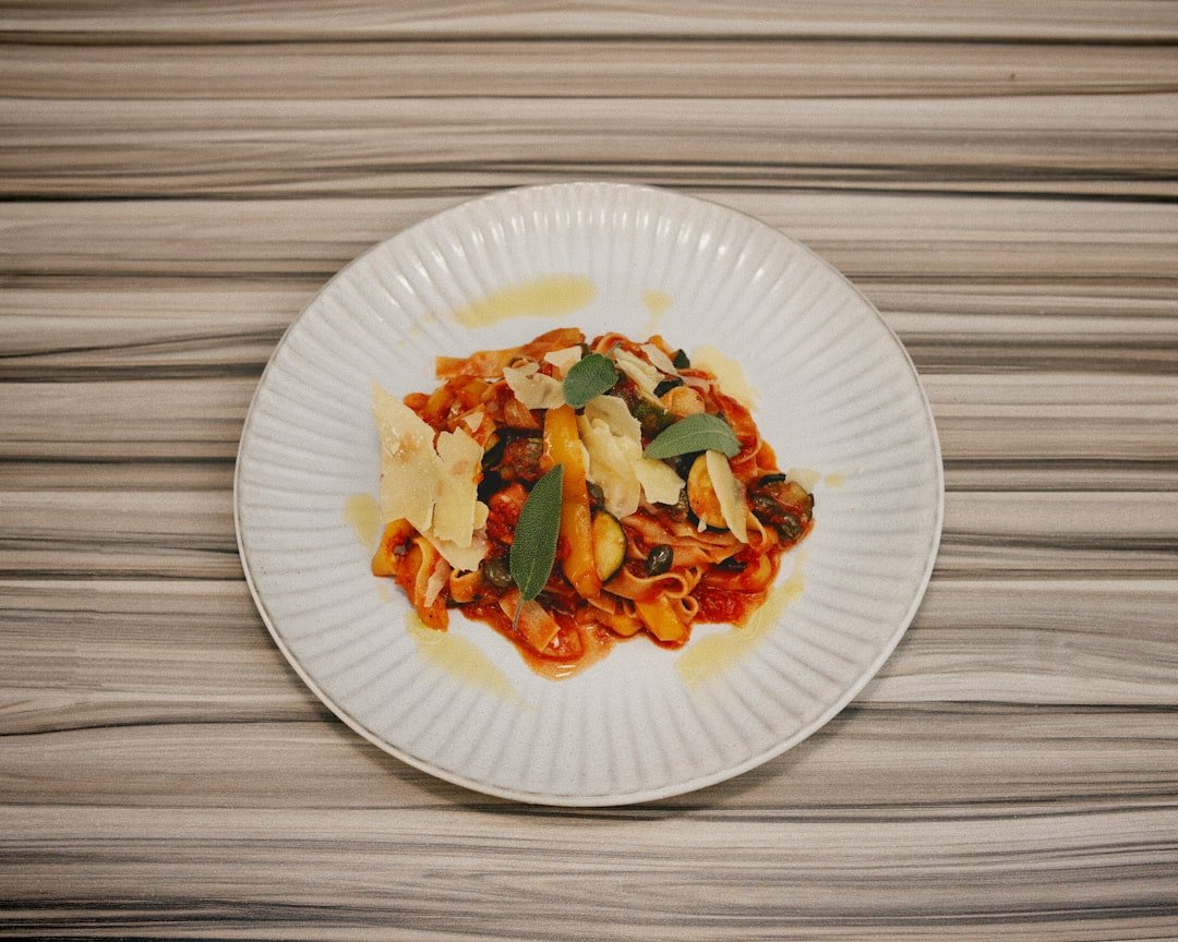 A simple, colorful weeknight dinner plate with pasta and vegetables, warm kitchen lighting